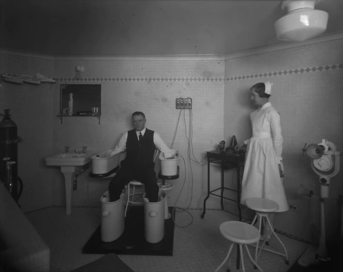 A man immerses his hands and feet in a Schnee Bath — which was used to treat ailments such as rheumatoid arthritis — in this 1931 photo taken inside the Château Laurier's 'special treatment room.' (Library and Archives Canada)
